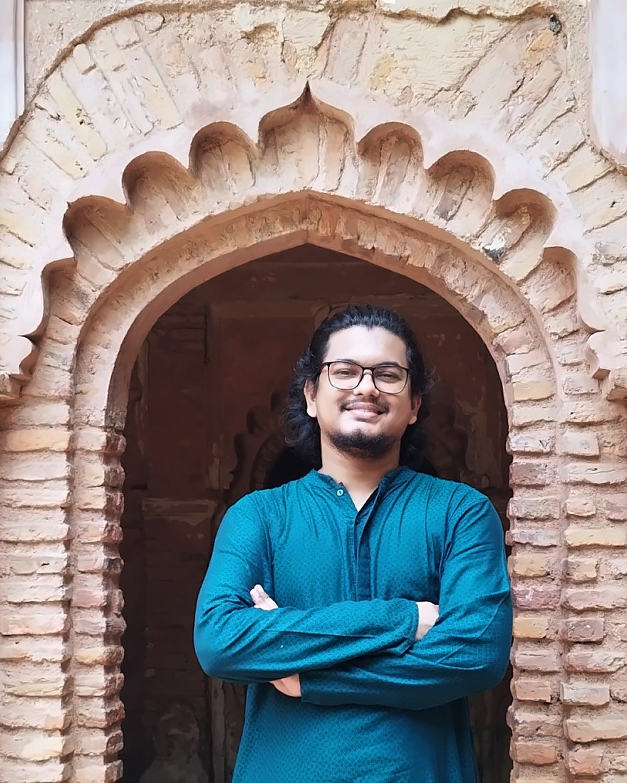 Portrait of Md Tamjid Al Noor Pobon standing in front of a carved brick archway